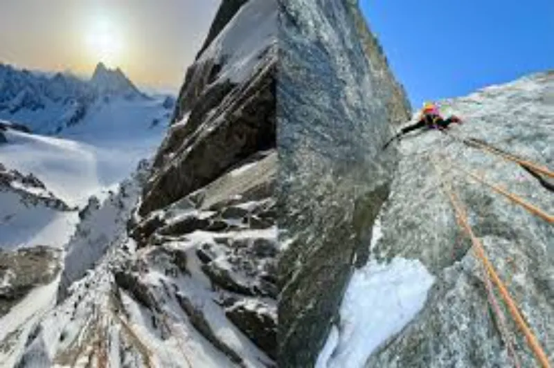 Alpiniste en pleine ascension sur une paroi rocheuse verticale