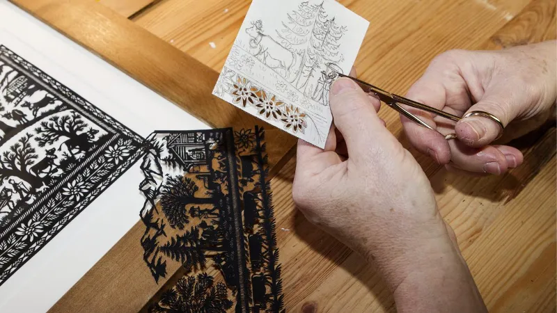 Oeuvre d'art artisanale réalisée en découpage papier noir sur fond blanc