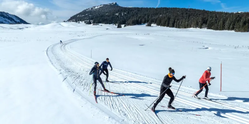 Skieurs sur une piste ensoleillée face au Mont-Blanc