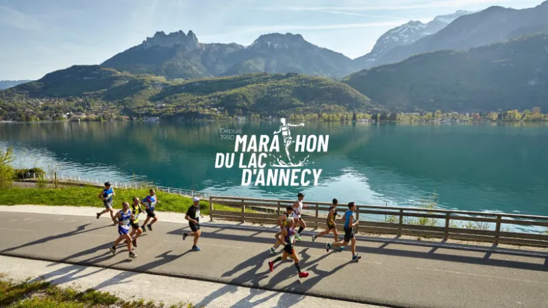 Peloton de coureurs longeant le lac d'Annecy lors du marathon