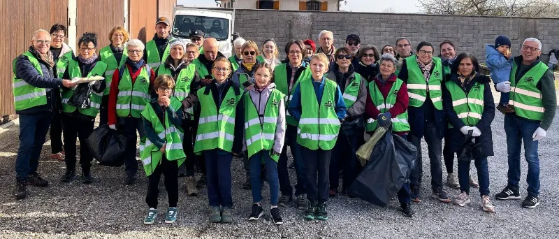 Bénévoles ramassant des déchets au bord de l'eau avec des gants et des pinces