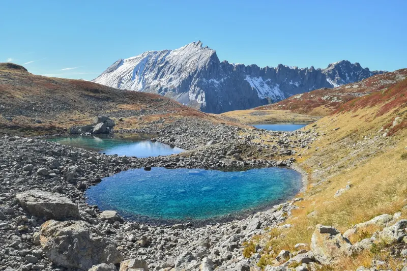 Tente de bivouac installée en haute montagne face à un glacier alpin