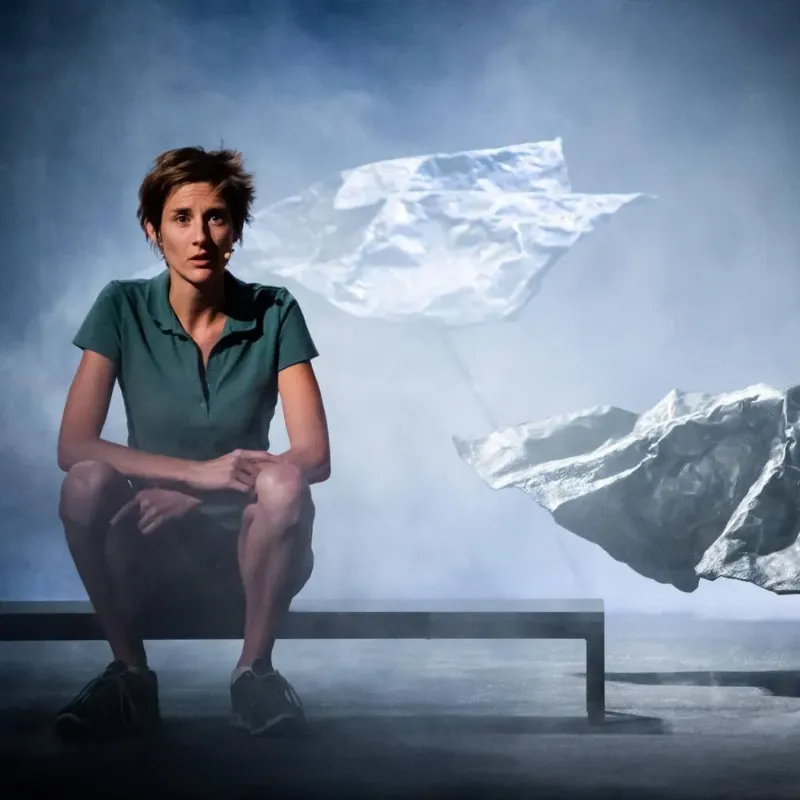 Alpiniste face à une immense paroi enneigée